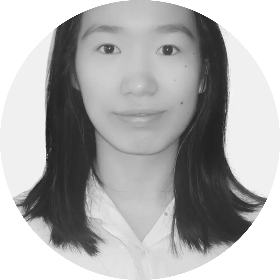 A black and white portrait of a person with shoulder-length hair. They are looking directly at the camera with a neutral expression and wearing a collared shirt. The image has a circular frame.