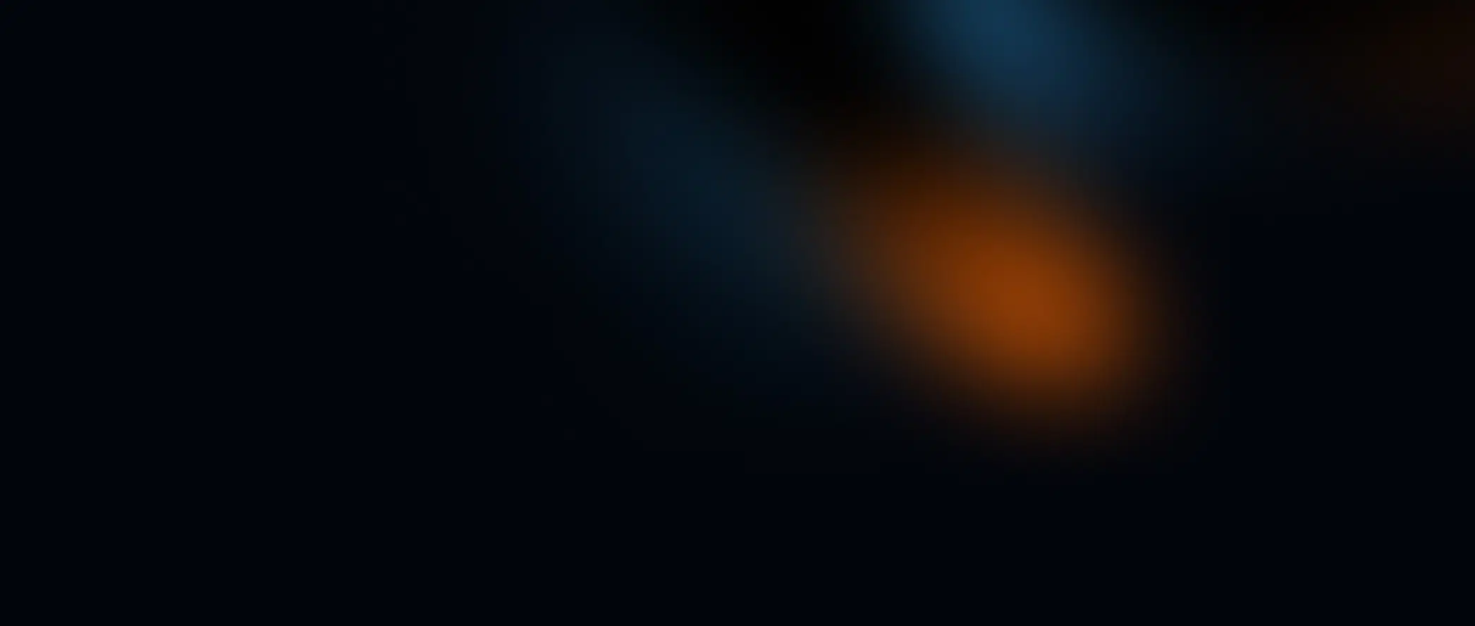 A dark background with two blurred streaks: one orange and glowing near the bottom right, and one faint blue near the top. The image has an abstract, out-of-focus appearance.