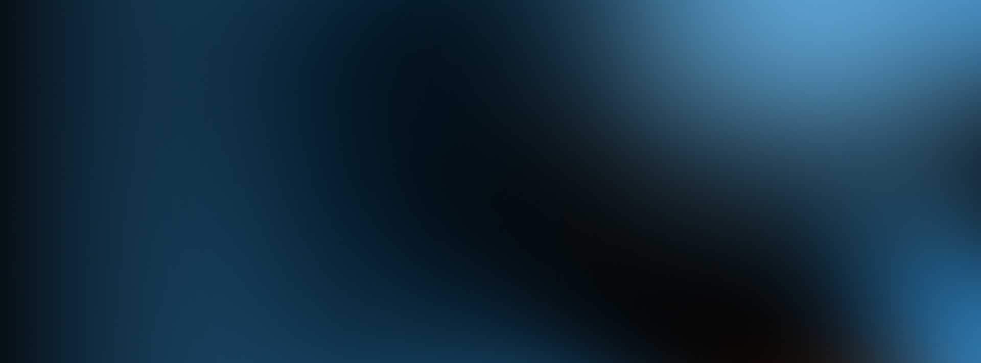 A blurred image with shades of blue and black blending together, creating an abstract and smooth gradient effect.