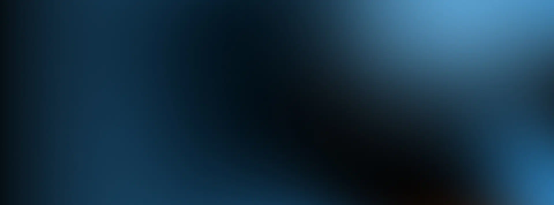 A blurred image with shades of blue and black blending together, creating an abstract and smooth gradient effect.